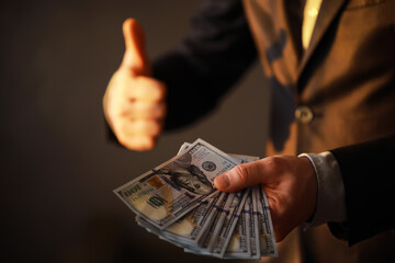 Wall Mural - Business Man Displaying a Spread of Cash over a gray vintage background