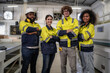 Group of factory workers wear safety uniform reflective jacket standing in plant floor. Diverse group of engineer people working together, portrait. Young adult men and women manufacturing teamwork.