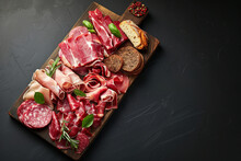 Board With Various Hams. Various Hams Or Beer Snacks On Wooden Board Isolated On Beautiful Empty Dark Background With Space For Text Or Inscriptions, Top View
