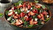 a strawberry spinach salad, with sliced strawberries, almonds, and feta cheese, drizzled with balsamic glaze