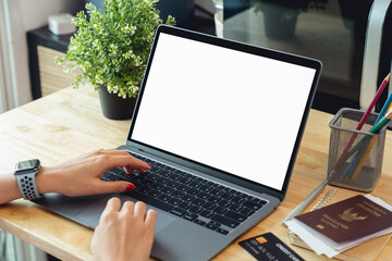 Sticker - Woman hand using laptop and typing on keyboard with mockup of blank screen on wooden table.