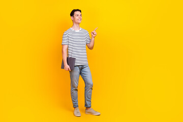 Sticker - Full length photo of diligent guy wear stylish t-shirt hold laptop look directing at offer empty space isolated on yellow color background