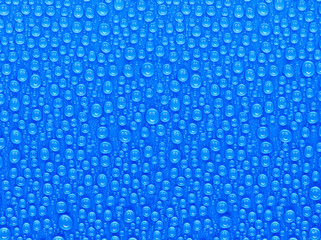 Wall Mural - many water drops on a blue surface, a smiley face is reflected in every drop