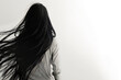 © VetalStock - A girl with beautiful long black hair stands back wall