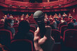 A hand holding a microphone in front of a full auditorium. The concept of public speaking. Illustration for cover, banner, poster, brochure, advertising, 