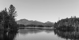 Fototapeta  - Kayaking in Boreas Ponds in the Adirondacks on a glassy lake with Mount Marcy and the high peaks in the background as the sun is setting.