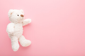 Wall Mural - Smiling white soft teddy bear on light pink table background. Pastel color. Empty place for text, quote or sayings. Closeup. Top down view.