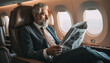 © YouAreBeautiful - A businessman in a tailored suit is reading a newspaper - relaxing in a first-class airplane seat during a flight - wide format