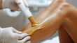 waxing legs, cosmetologist's hands remove hair from girl's skin, beauty salon, sugaring, smooth, self-care, lifestyle, spa salon, shins, knees, woman