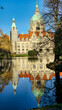 © TravelLensPro - Hanover Maschpark new town hall with beautiful tree reflection in the lake water