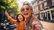 Amsterdam travel destination. Tourist joyful Asian senior citizens couple on sunny day looking at beautiful cityscape. The concept of traveling to different parts of the world