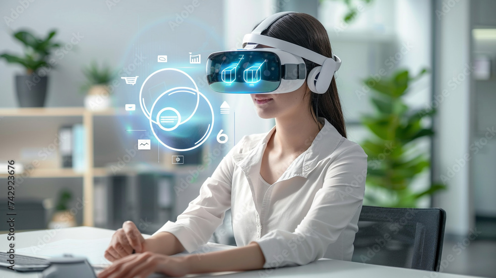 Attractive business woman sitting at an office desk wearing a VR ...