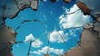 A broken glass window, poignantly reflecting the blue sky