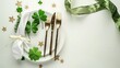Top view Festive table setting for St.Patrick's day with cutlery, decorative clover leaves, gift and gold stars on white table