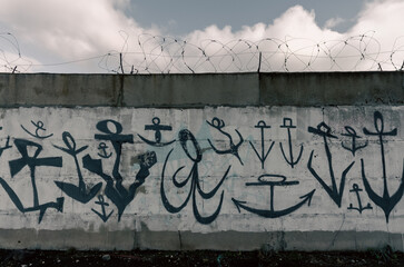 old stone fence with graffiti many anchors