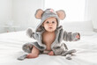 © Louis-Photo - Adorable baby boy in white sunny bedroom wearing mouse Bathrobe