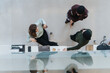 © qunica.com - An aerial perspective captures two office workers engaged in a casual meeting at a standing desk.