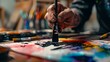 © Alex - Artist at work: a close-up of a hand painting with vibrant colors on a palette