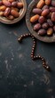 Dates fruits and rosary on dark background. Top view
