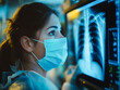 A female doctor is looking at the lung X-ray results of a patient on the display screen of the machine for diagnosis in the treatment of diseases.