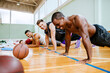 © Marko Geber - Exhausted basketball player resting on the court with teammates