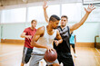 © Marko Geber - Men playing basketball in indoor gym