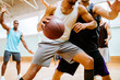 © Marko Geber - Men playing basketball in indoor gym