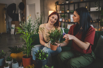 two women friends sisters plant flowers together take care of plants