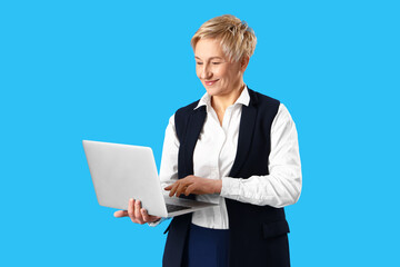 Mature female programmer working with laptop on blue background