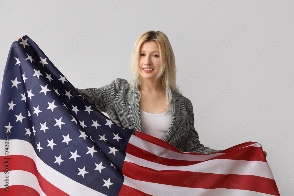 Young businesswoman with USA flag on grey background