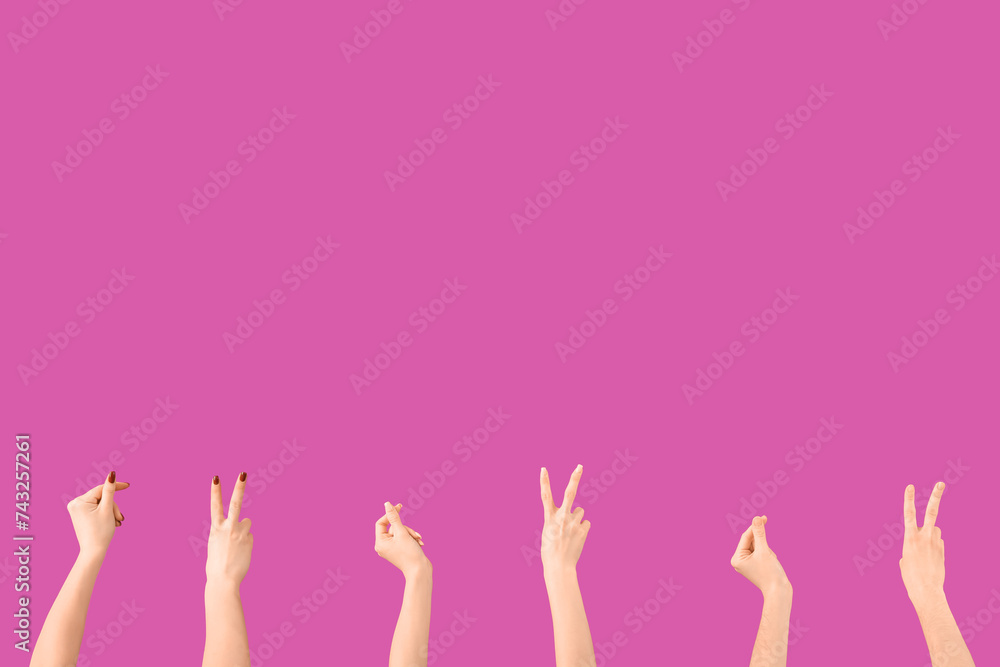 Female hands showing peace gestures and holding something on purple background