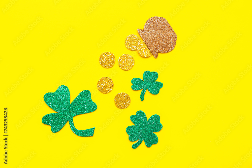 Paper pot with golden coins and clovers on yellow background. St. Patrick's Day celebration