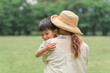 公園・草原で子供を抱っこするママ（甘えん坊・甘える）
