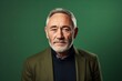© Chacmool - Portrait of a senior man with grey hair and beard on a green background.
