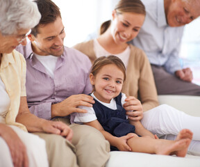 Poster - Portrait, big family and happy kid on sofa in home for bonding, love or child relax together with parents. Face, grandparents and girl with mother and father in living room with smile for connection