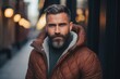 Portrait of a handsome bearded man in a warm jacket in the city
