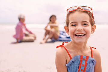 Canvas Print - Portrait, smile and little girl on beach in summer with family for travel, holiday or vacation. Face, relax and sunshine with happy young child on sand by ocean or sea for tropical weekend getaway