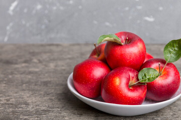 Wall Mural - juicy red apples in a bowl or plate on the table top view. Copy space