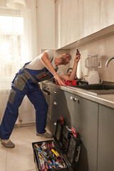 Wall Mural - Handyman fixing kitchen cabinets in the apartment.