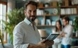 © radekcho - Elegant male real estate agent using tablet looking at the camera, in the background a couple looks at the apartment.