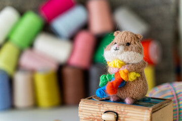 Knitted hamster toy with yarn and knitting accessories