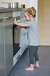 © AGDER - Little girl in a kitchen opening the door of an oven