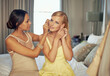 © peopleimages.com - Friend, helping and earrings in hotel for event, bonding and elegant fashion to celebrate at gala party. Women, bedroom or support with accessories or dressing or excited together for formal dinner