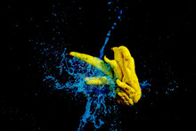 A Captivating Image Of A Buddha's Hand Citron With A Dynamic Blue Liquid Splash Against A Stark Black Background