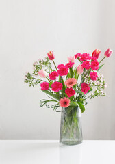 Wall Mural - pink spring flowers in glass jug on white background