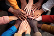 Group of diverse hands joining together, view from above