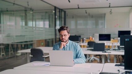 Busy professional business man company employee, young male worker software developer, latin businessman typing on computer technology using laptop searching on web working at office workplace desk.
