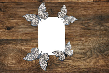 Wall Mural - Wedding invitation card mockup decorated with butterflies on wood table. Blank card mockup