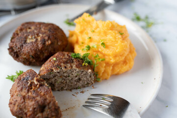 Wall Mural - German meatballs with potato puree and sweet potatoes on a plate. Traditional cuisine