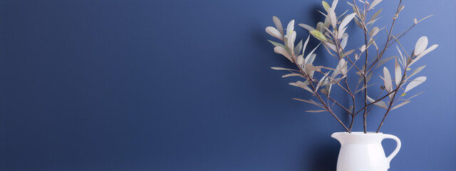 Blue background with a white vase and gray leaves